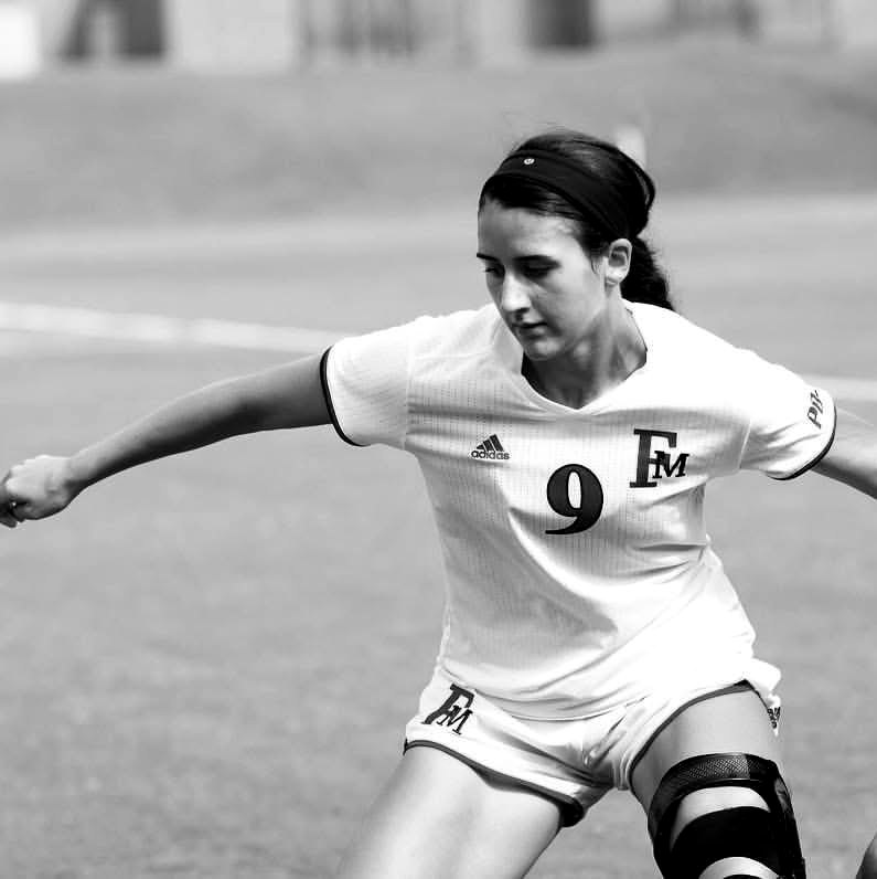 Melina Much playing forward for Francis Marion University, wearing a knee brace.